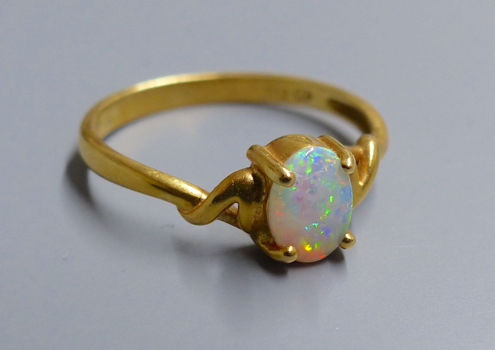 An 18k and single stone white opal ring, size O, gross 2.5 grams.